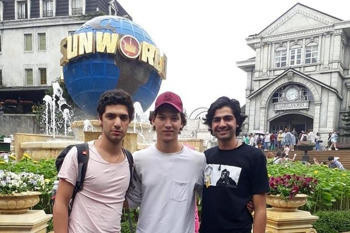 tre uomini sono in piedi davanti a una fontana