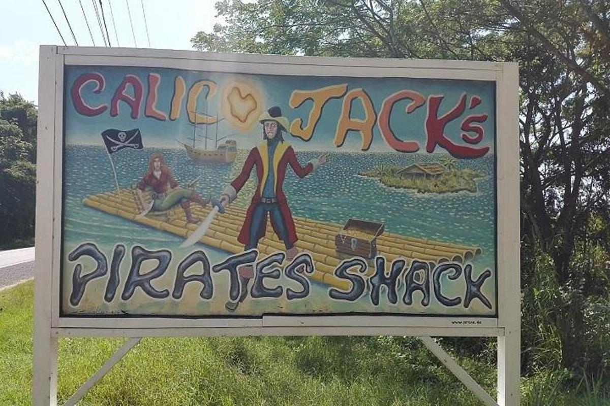 Un cartel que indica una choza de piratas con una pintura en él.