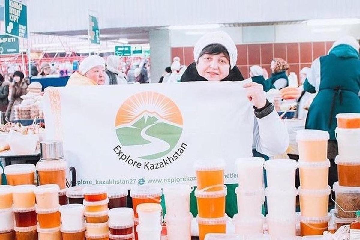 una dona que sosté un cartell davant d'ampolles de cervesa