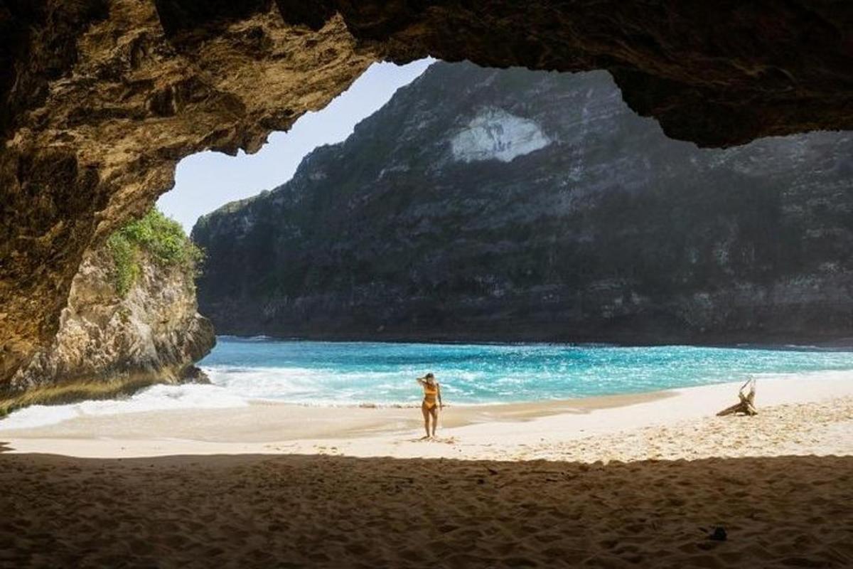 una persona in piedi su una spiaggia vicino all'oceano