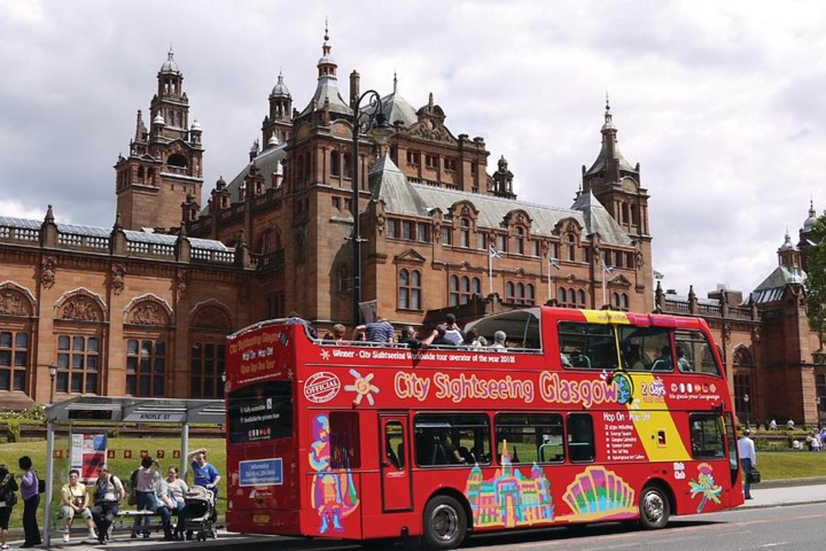 a red double decker bus in front of a building