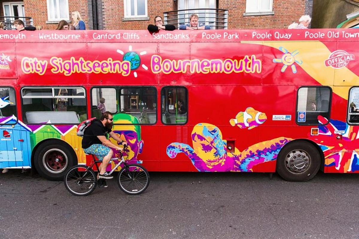 ein Mann, der neben einem roten Bus Fahrrad fährt