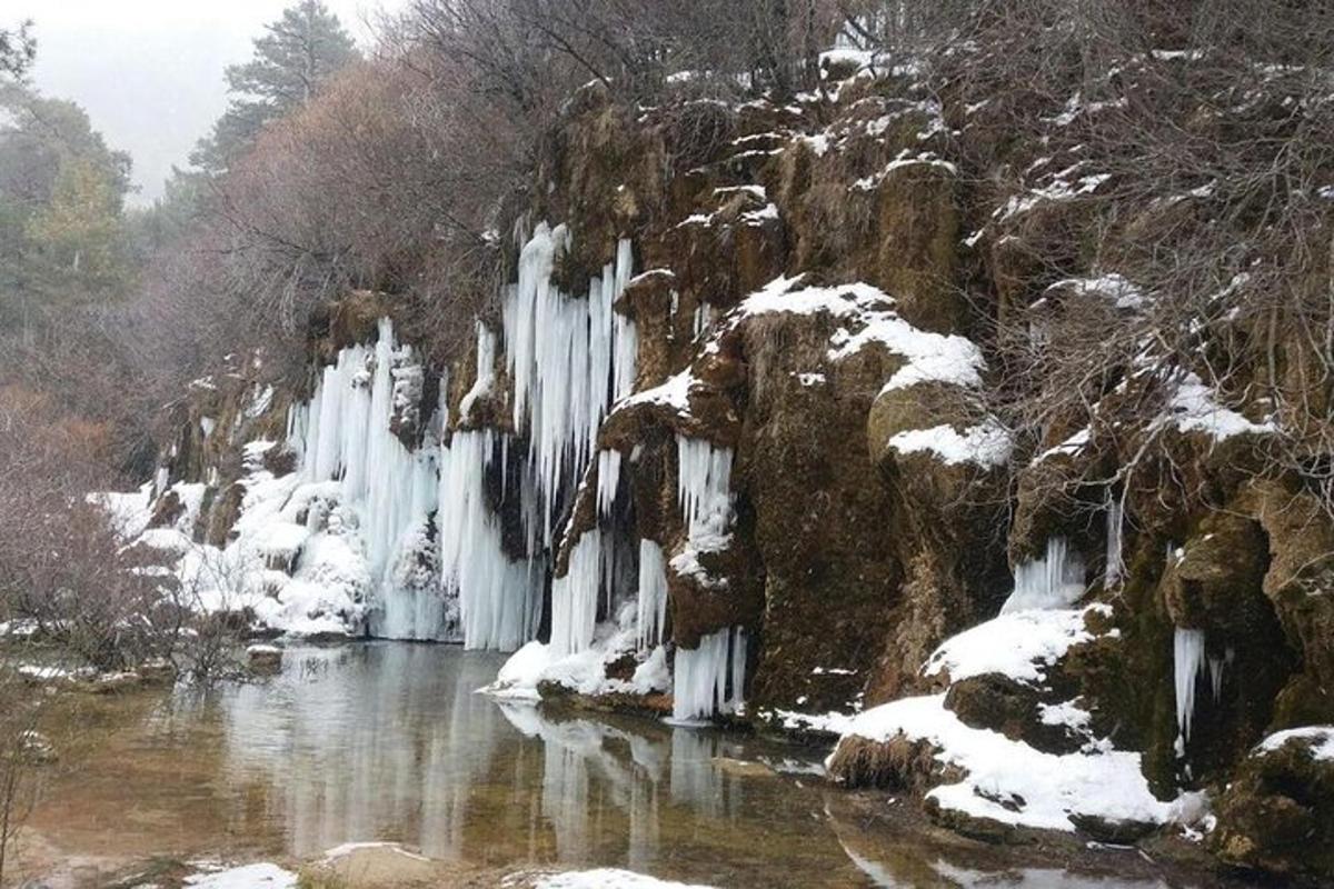 uma cachoeira com pingentes de gelo em um rio na neve