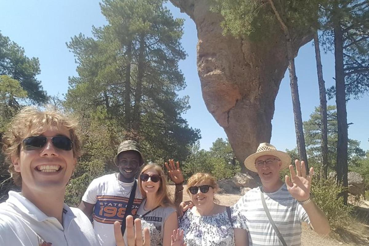 um grupo de pessoas posando para uma foto em frente a uma árvore