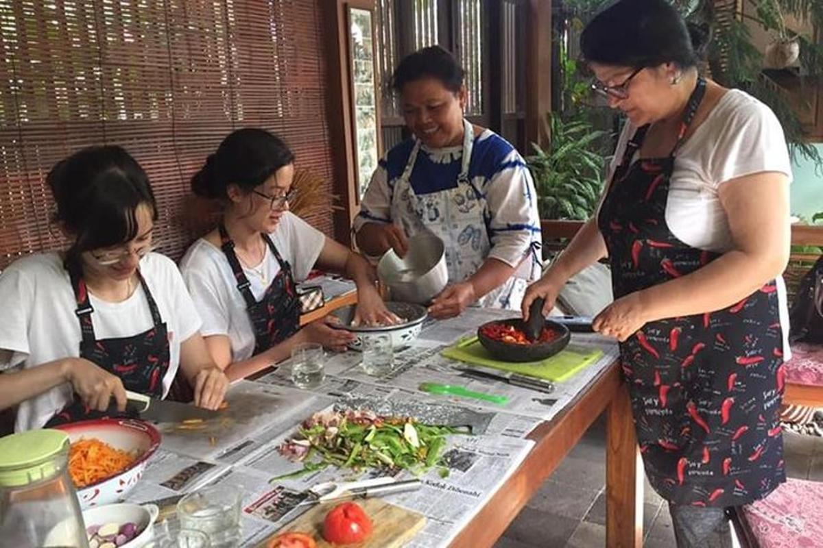 un gruppo di persone in piedi attorno a un tavolo che prepara il cibo
