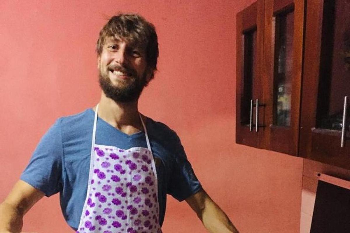 a man standing in a kitchen wearing a apron