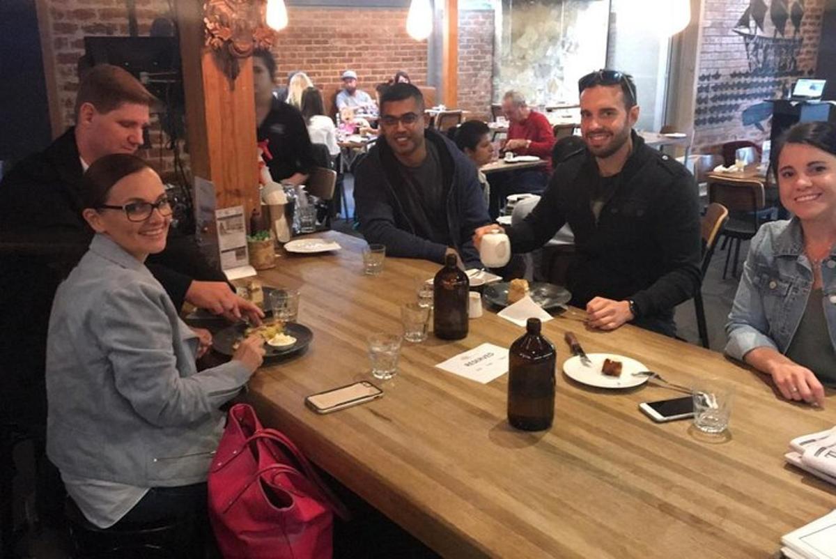 skupina lidí sedících kolem stolu v restauraci