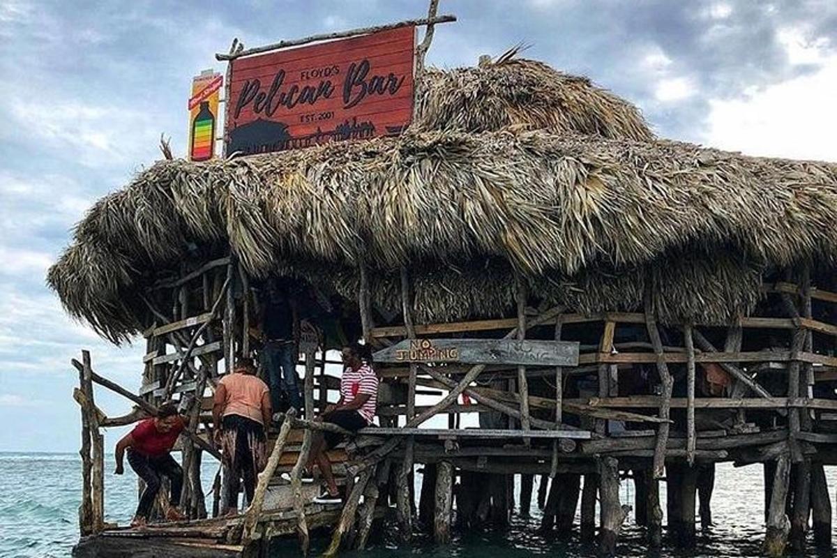 un gruppo di persone in piedi nell'acqua su una capanna nell'oceano