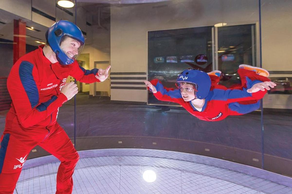 a man and a young boy in red jumps on a trampoline