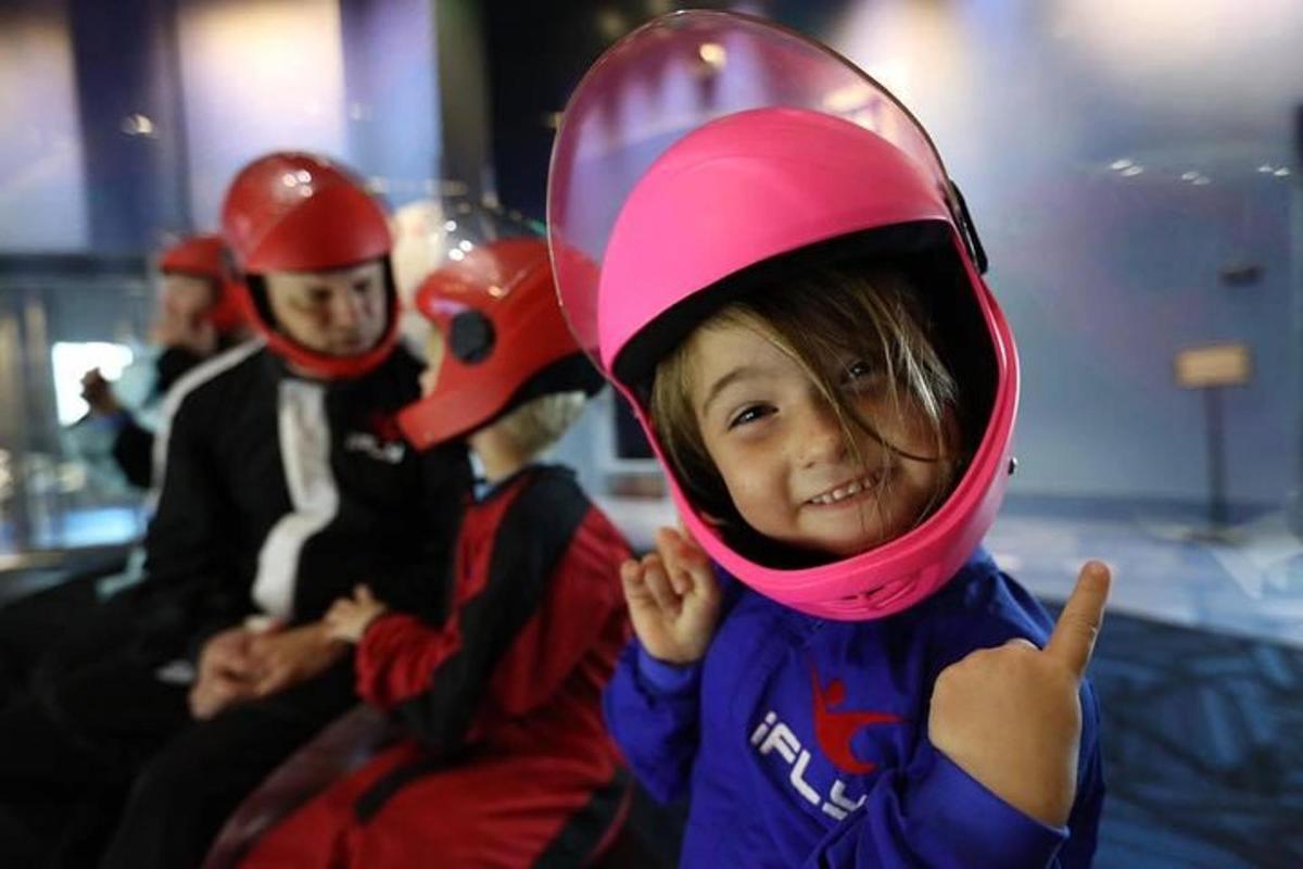 un bambino che indossa un casco e fa un gesto di pollice in su