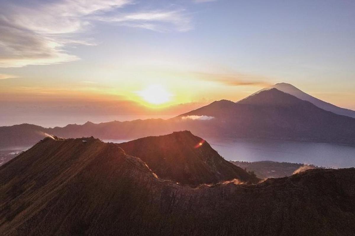 a sunset on top of a mountain with the sun setting