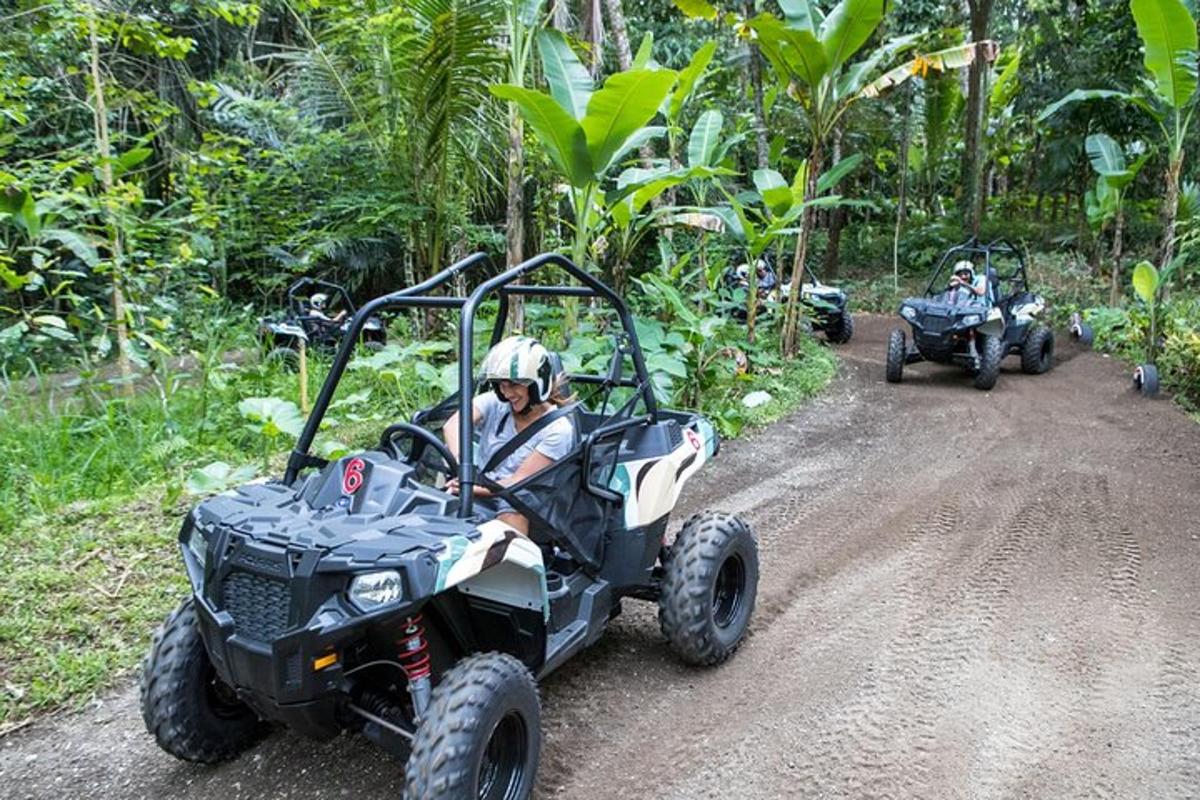 dues persones que condueixen quads per un camí de terra