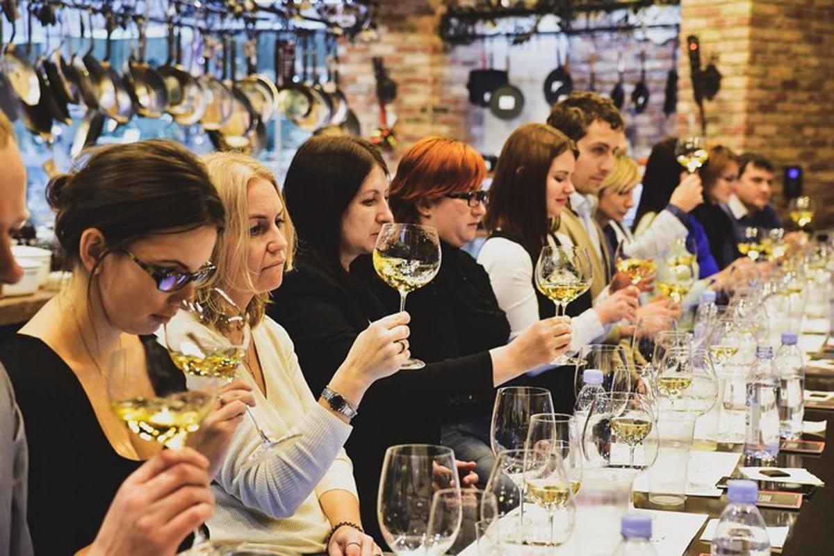 un gruppo di persone sedute a un tavolo con in mano dei bicchieri di vino