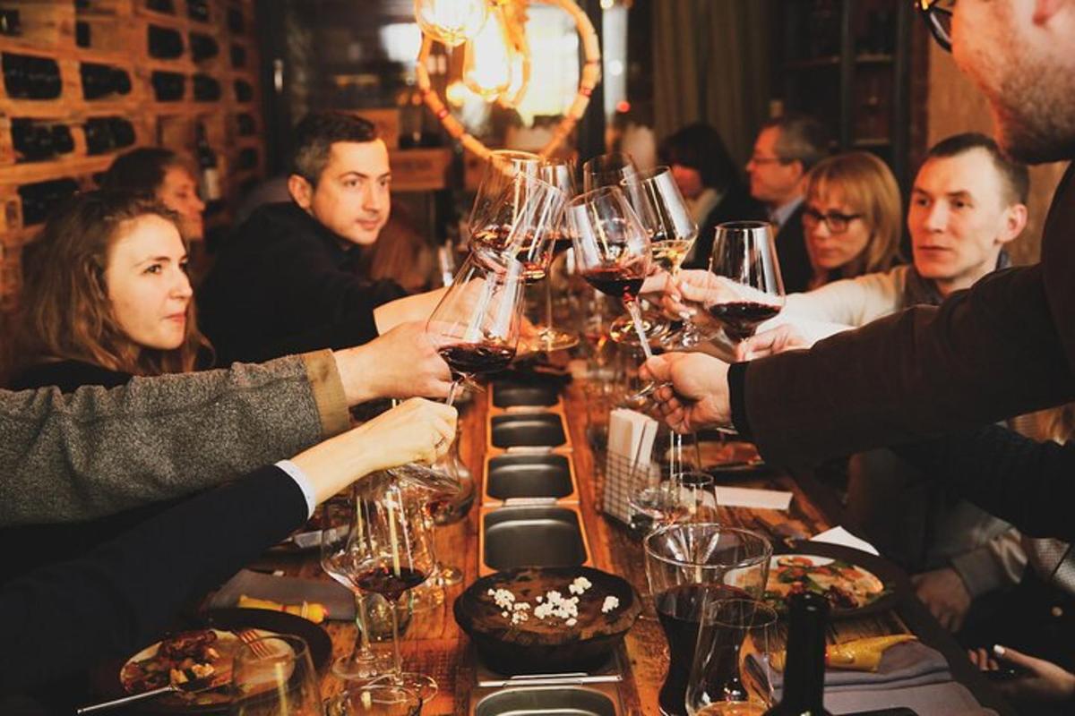 un gruppo di persone sedute attorno a un tavolo con bicchieri di vino