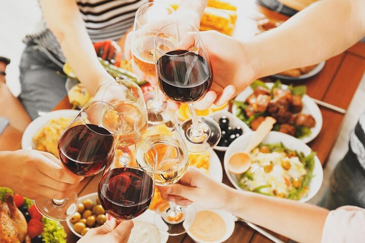 một nhóm người đang uống rượu vang tại một bàn ăn