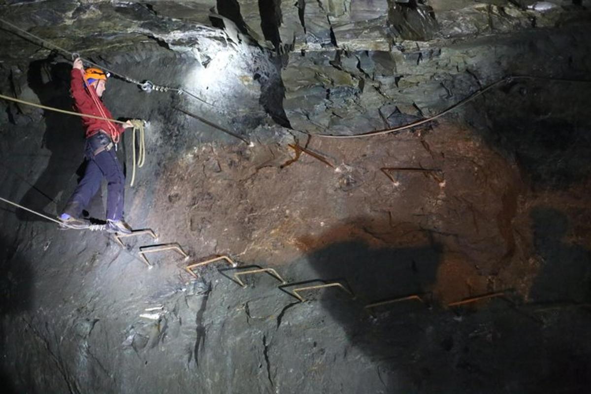 a man is on a rope in a cave