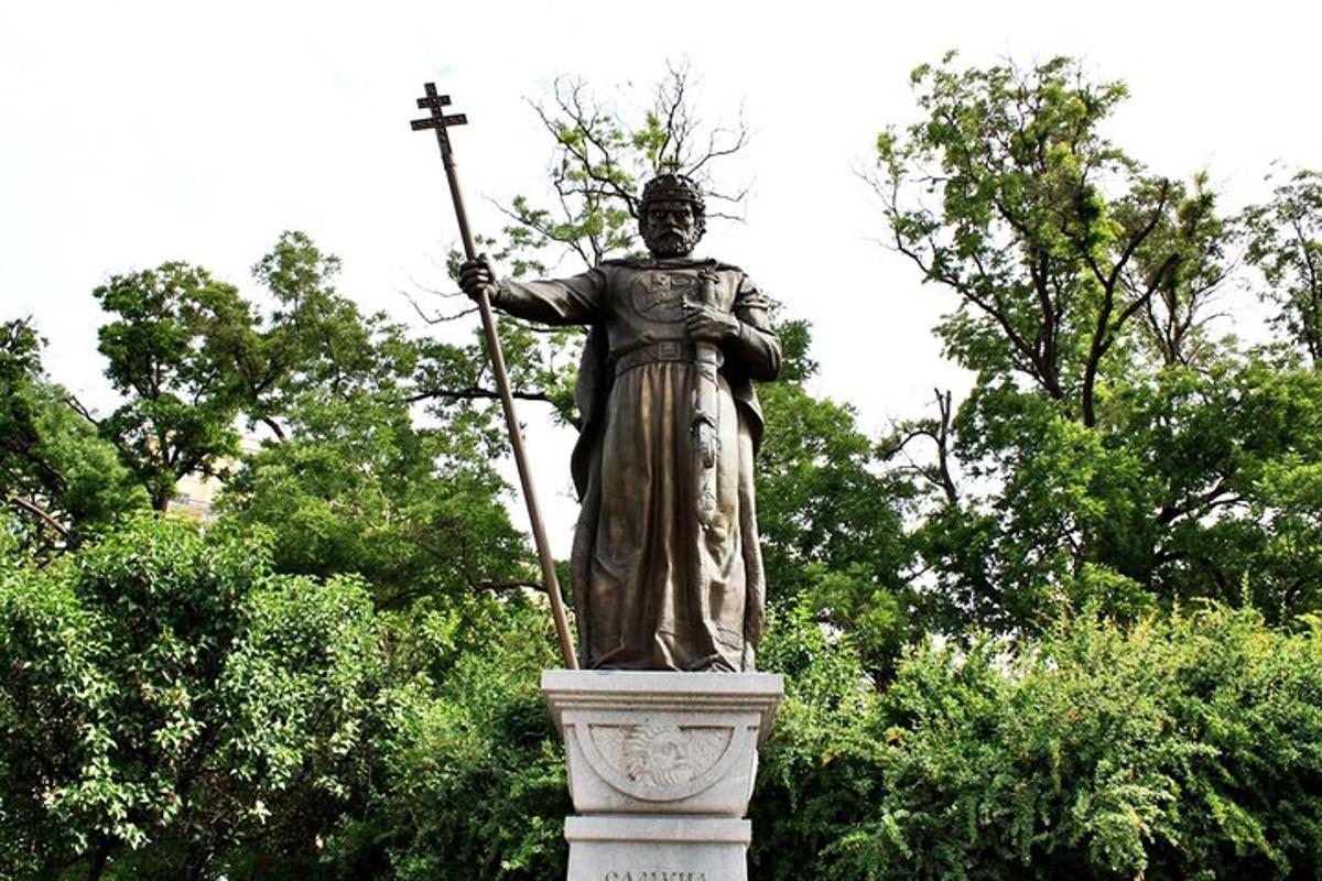 o statuie a unui bărbat care ține un baston și o cruce