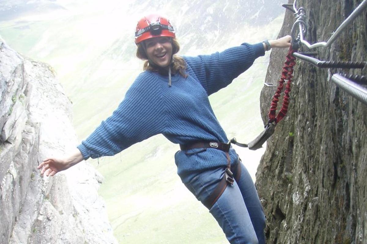 a woman is hanging on a rock wall