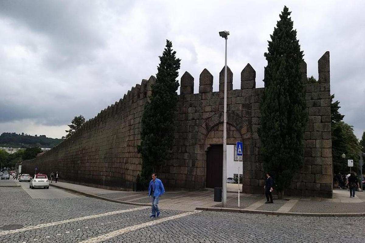un uomo in piedi davanti a un muro di mattoni