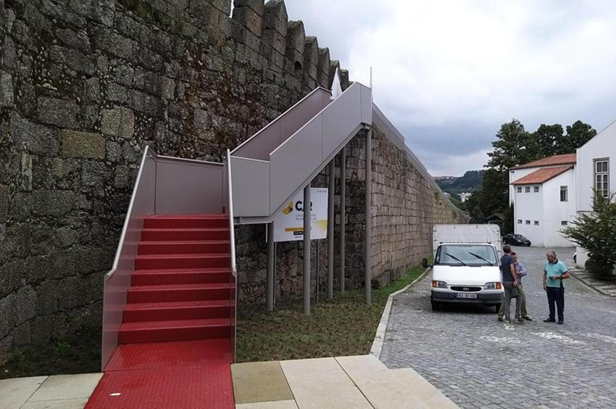 un edificio con una scala rossa accanto a un muro
