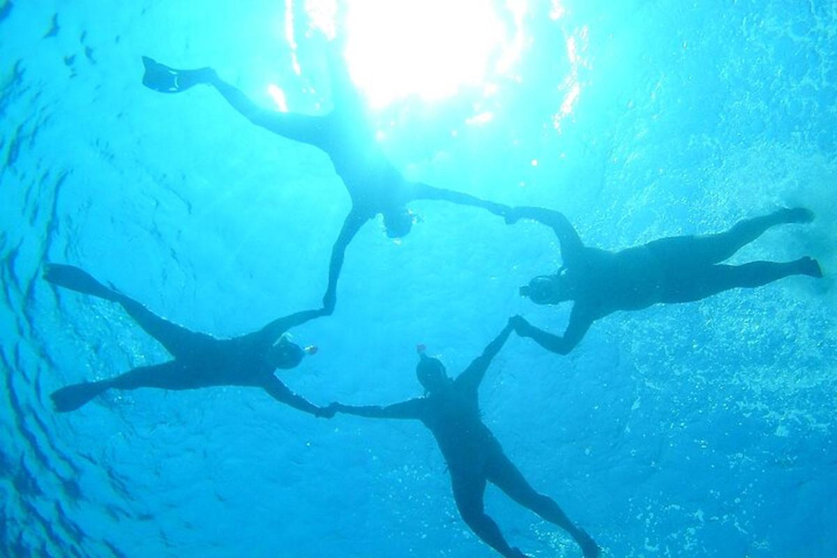 sekelompok tiga orang berenang di air