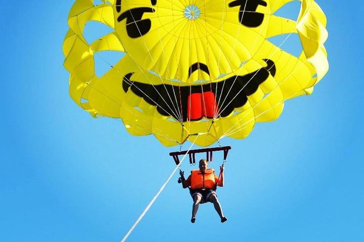 um homem voando um balão amarelo com um rosto sorridente nele