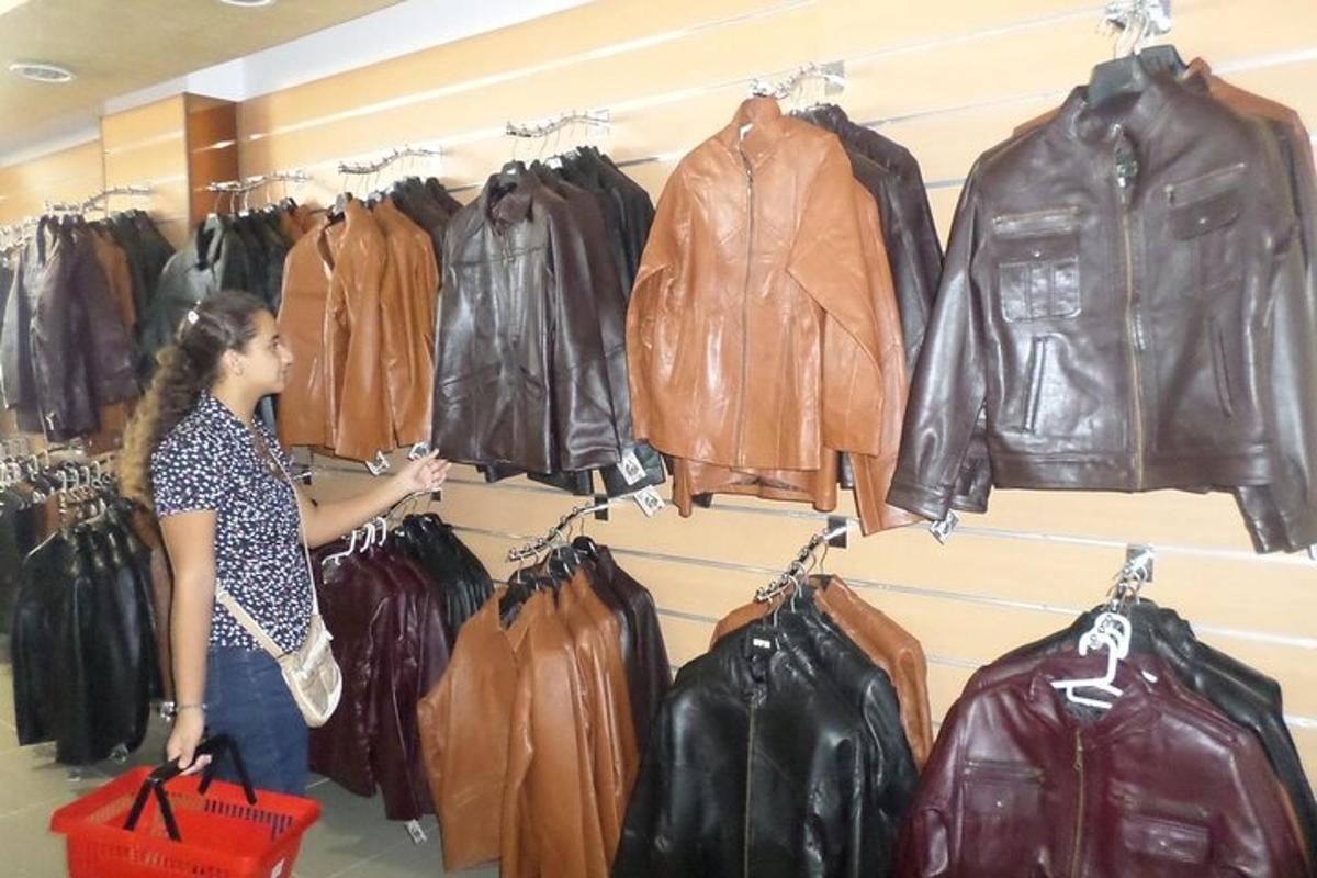 žena si prohlíží kožené bundy v obchodě