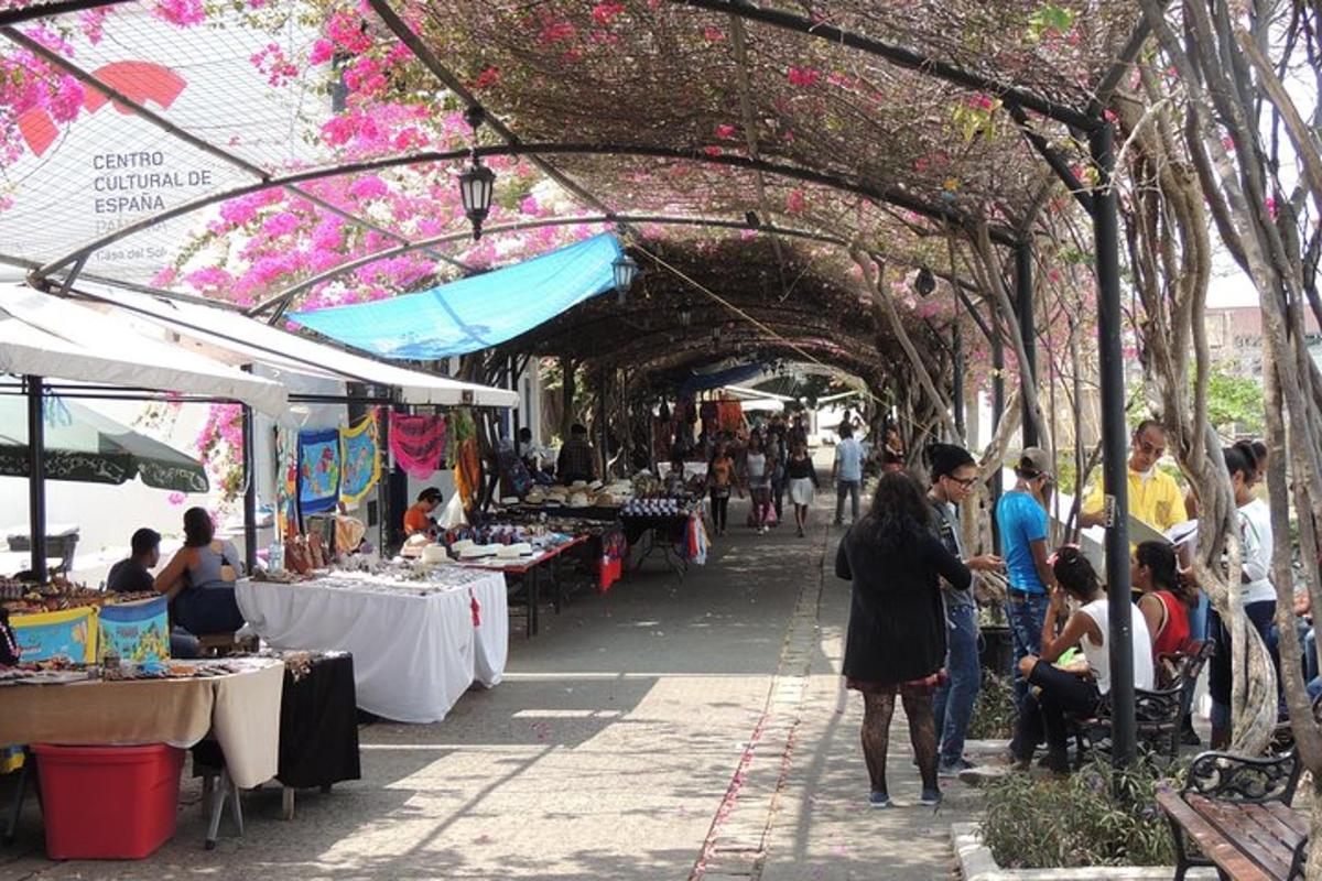 un gruppo di persone che camminano in un mercato all'aperto