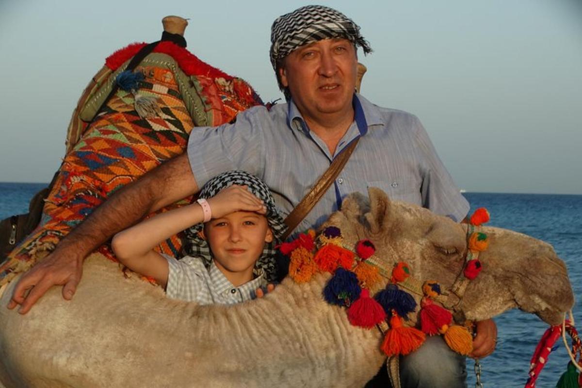 egy férfi és egy gyermek ül egy teve hátán