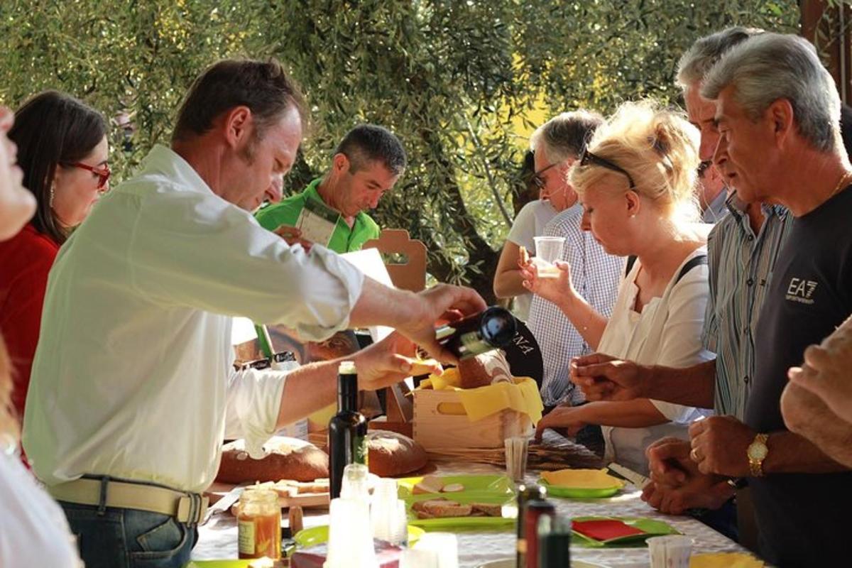 Un hombre sirviendo vino en una mesa con un grupo de personas.