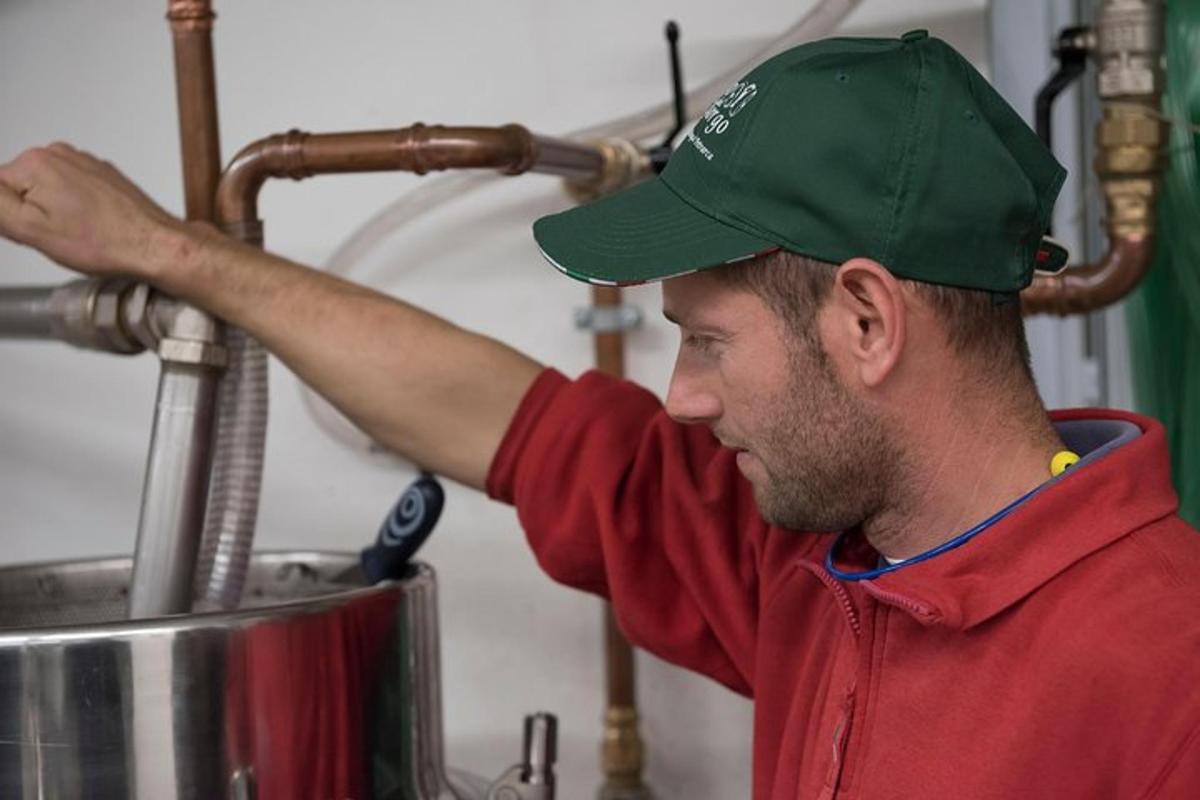 Un hombre con un sombrero verde de pie junto a una olla.
