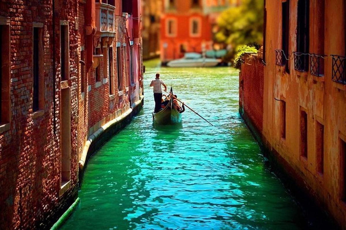 a man riding a gondola in a canal between two buildings
