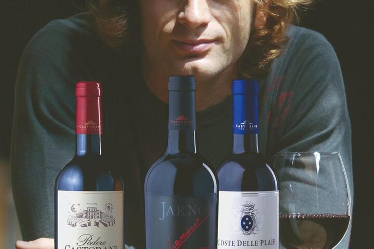 a man is holding three bottles of wine