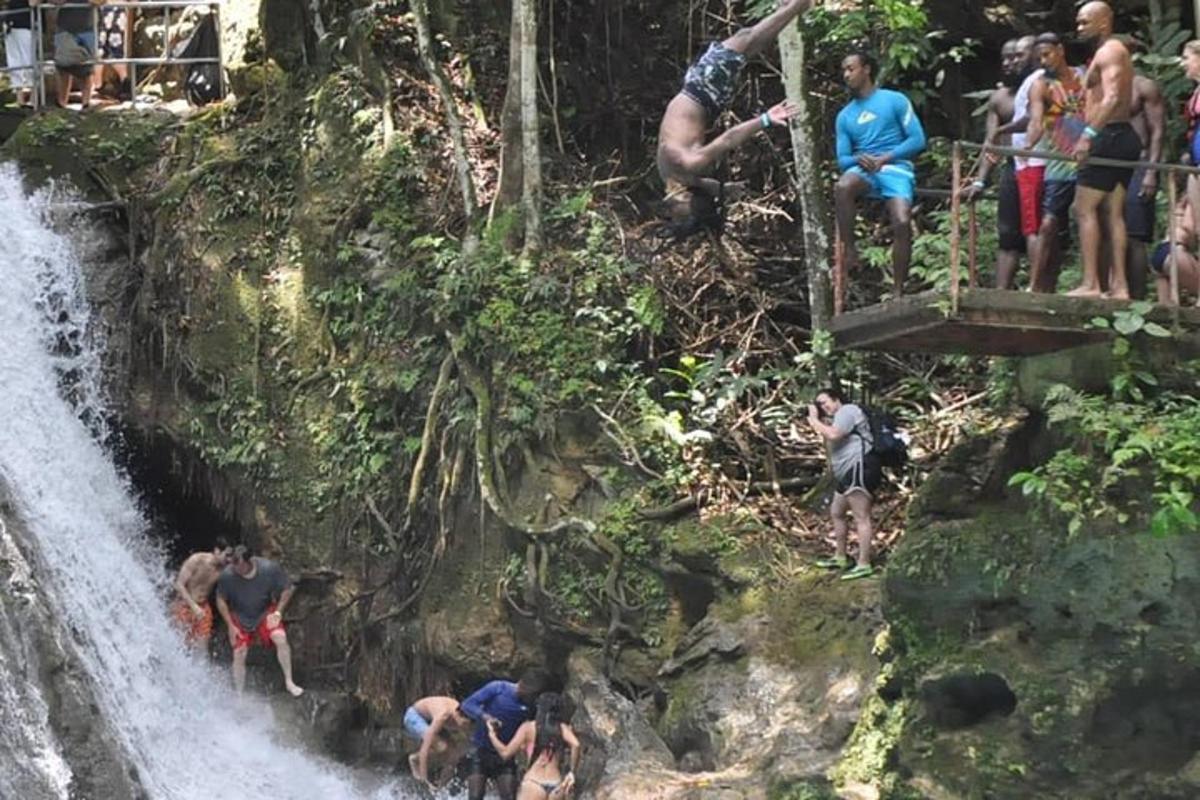 un gruppo di persone su un ponte vicino a una cascata