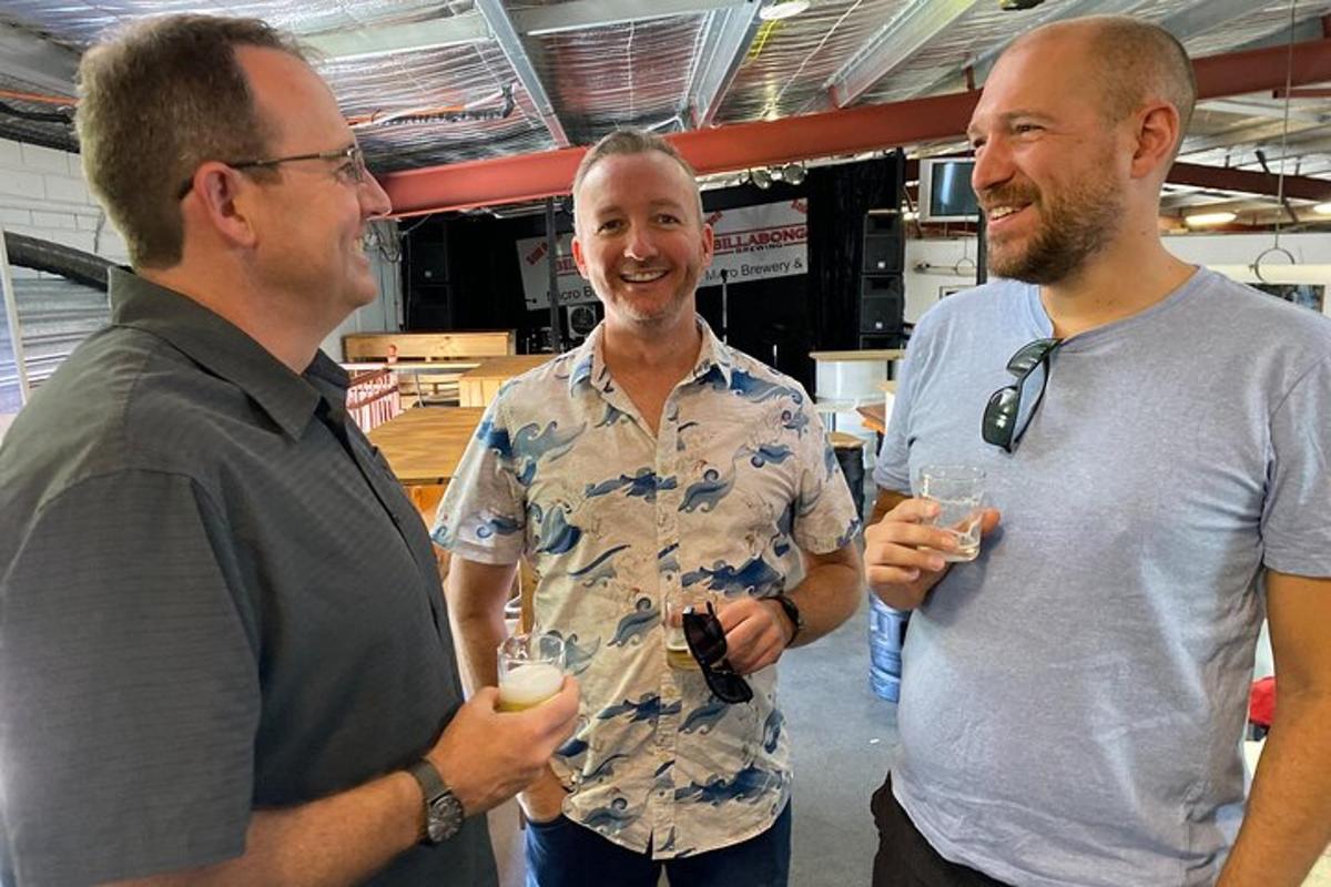 Tres hombres de pie uno al lado del otro sosteniendo copas de vino