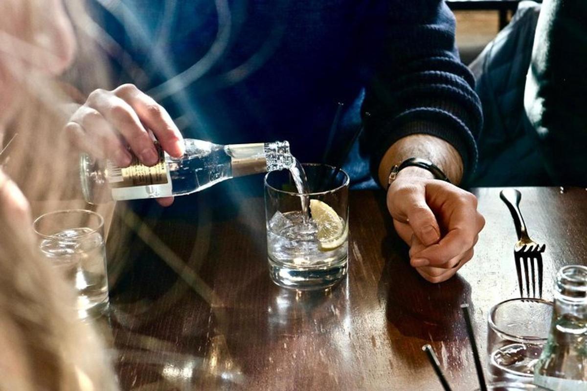 a person pouring a drink into a glass