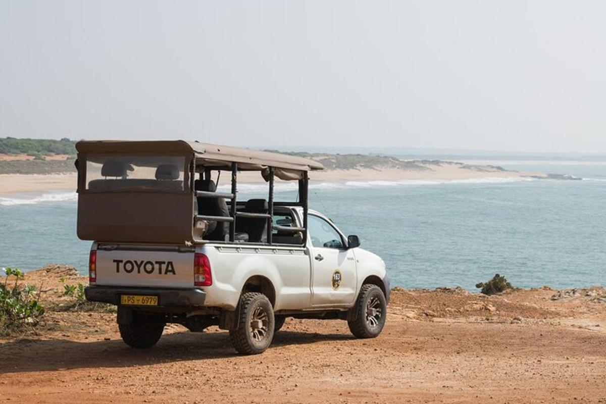 a white jeep parked on a beach near the ocean