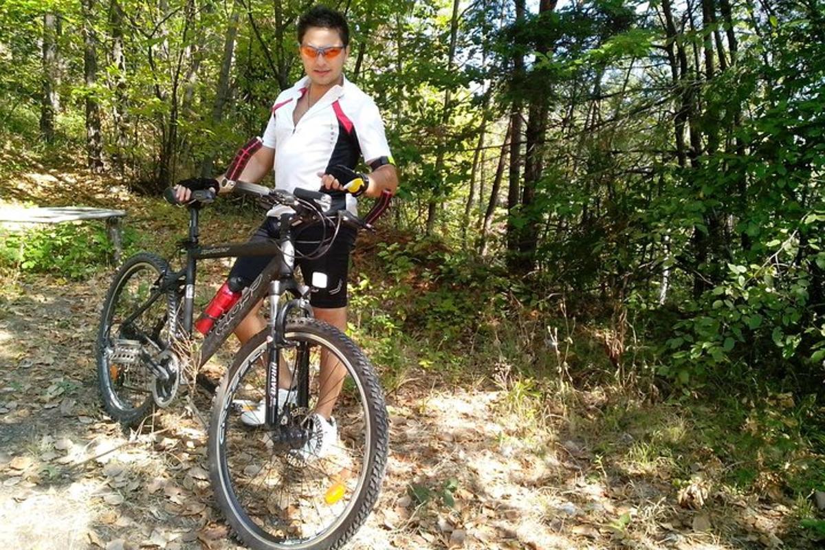 un uomo in piedi accanto a una bicicletta su un sentiero