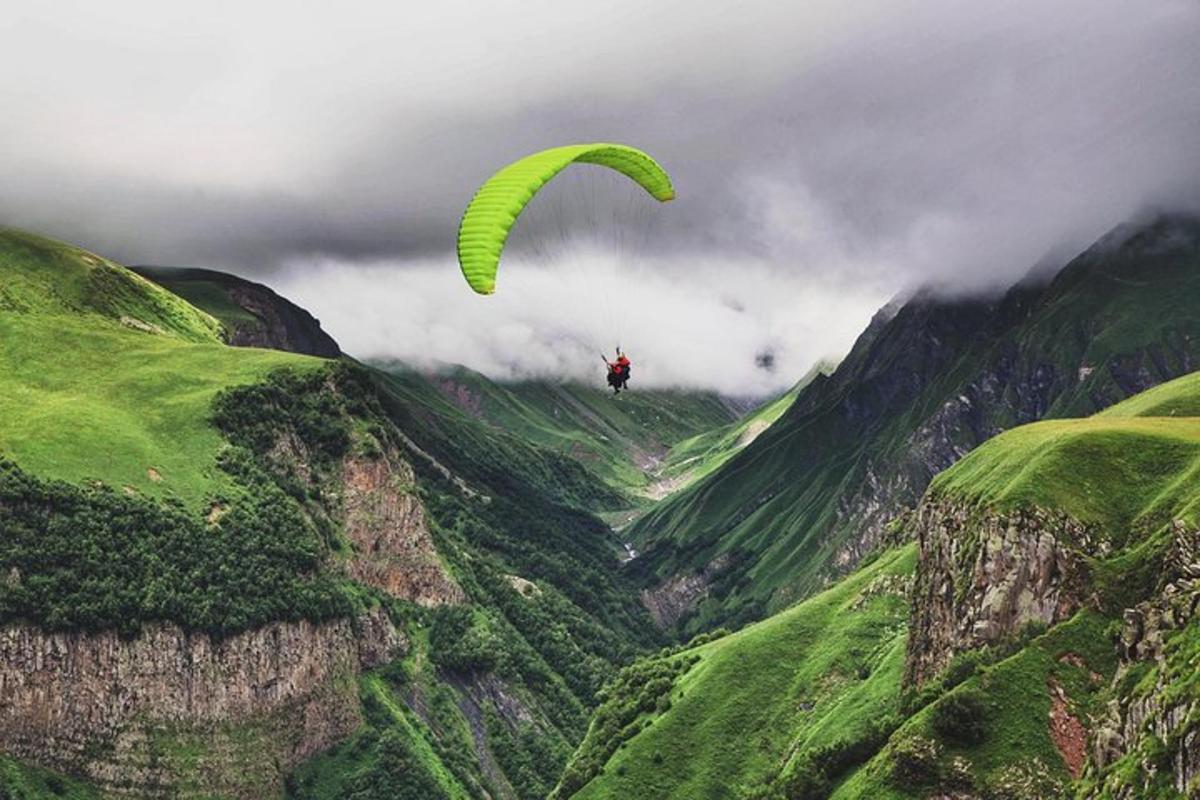 una persona che vola su un parapendio sopra una montagna