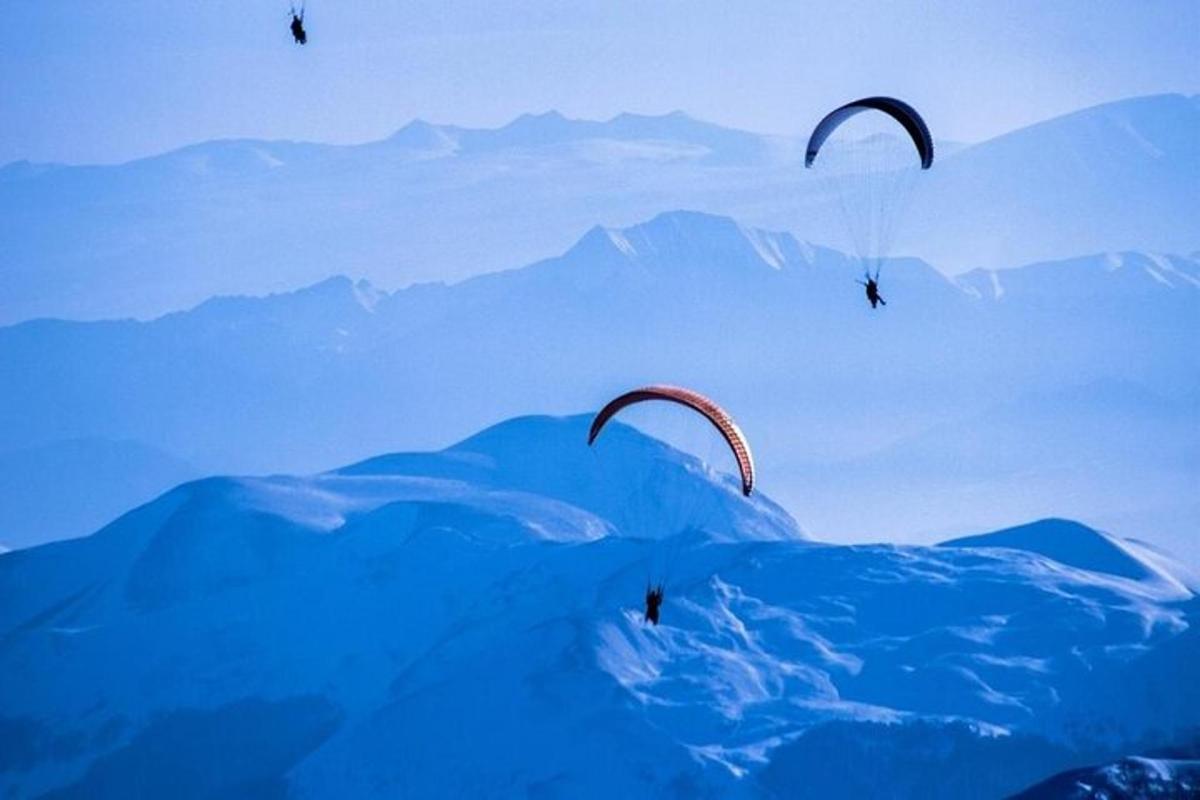 dua paraglider terbang di langit di atas gunung