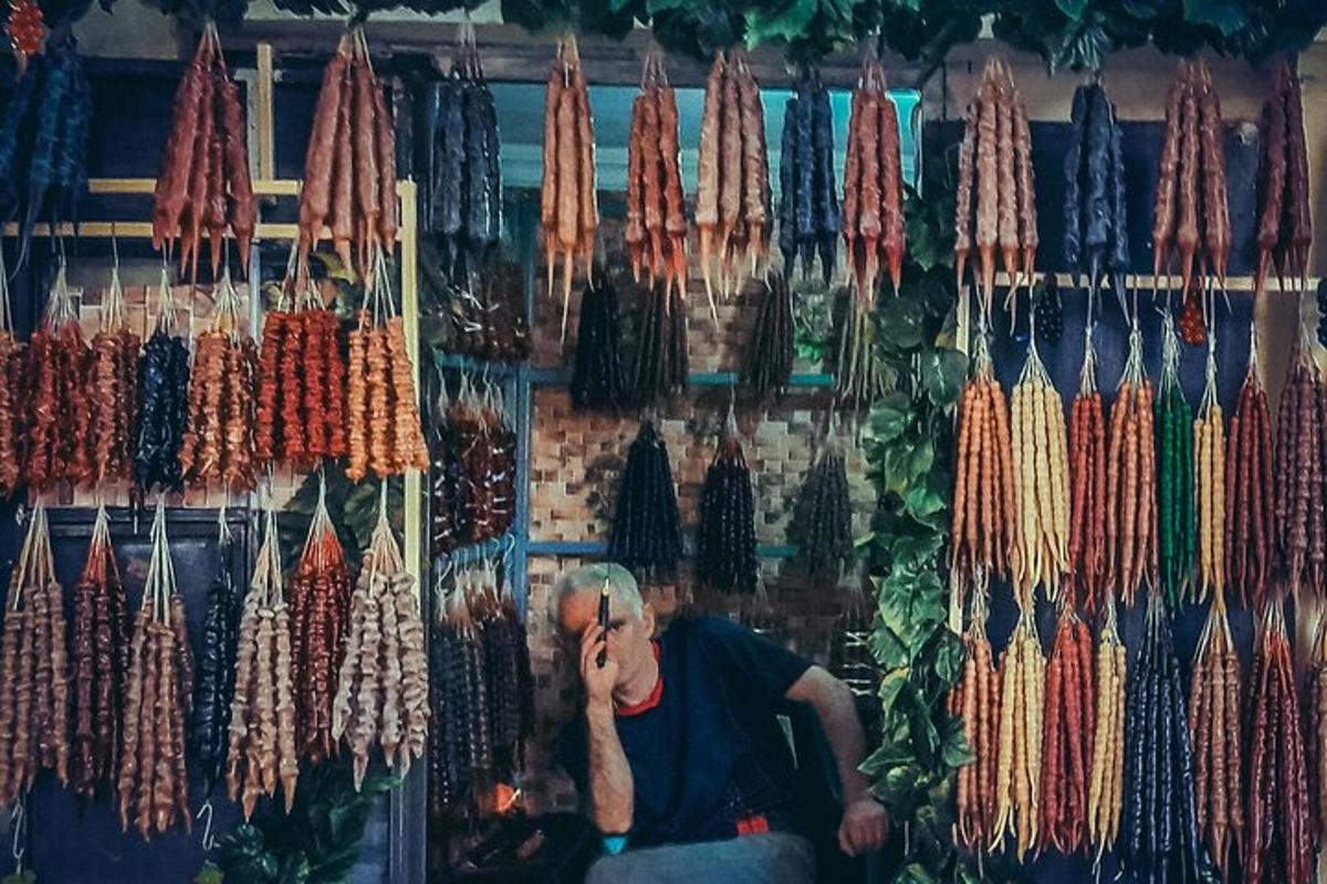 un uomo seduto davanti a una mostra di fili di diversi colori