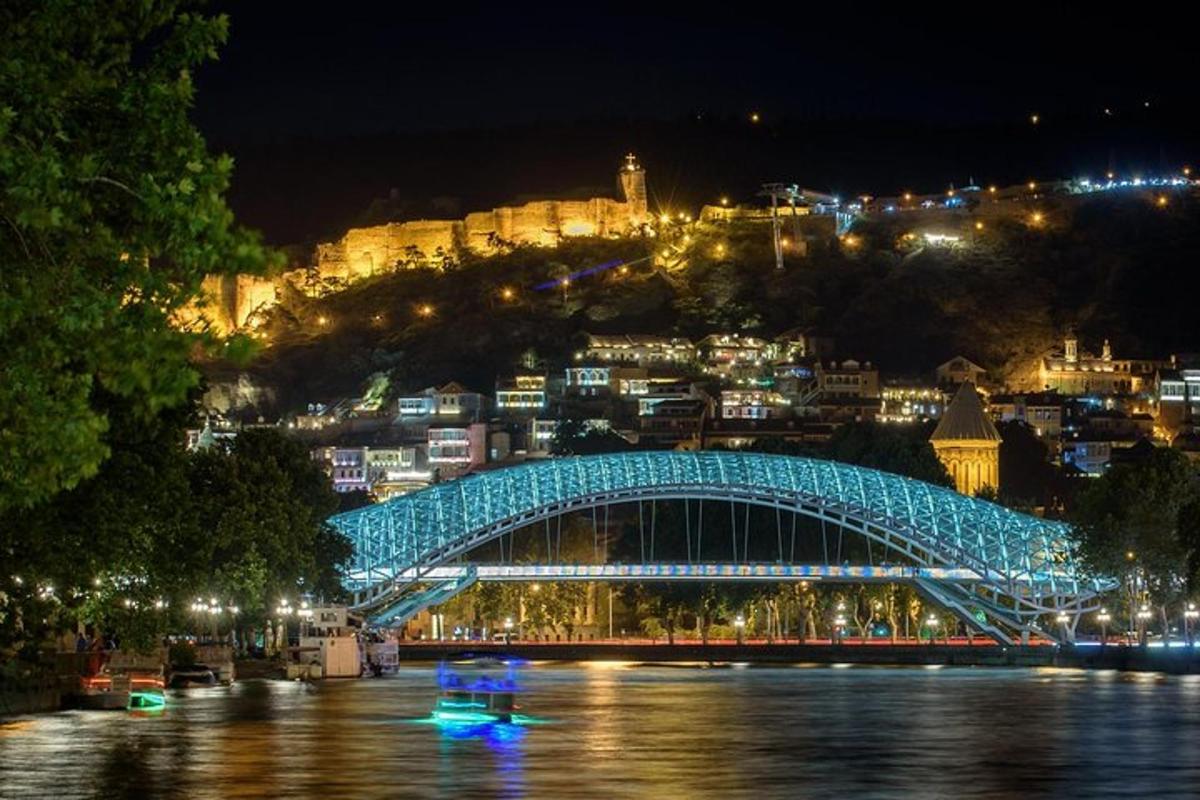 a blue bridge over a river with a city at night