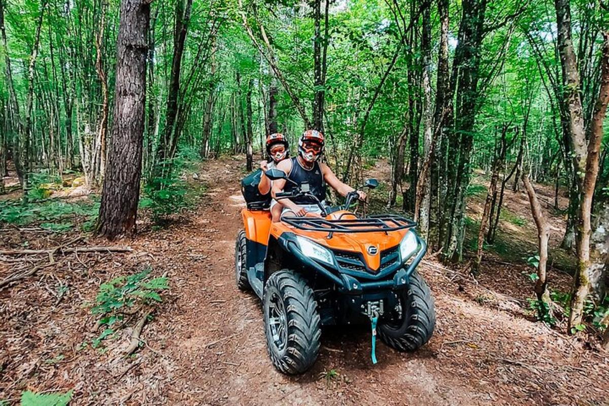 two people riding on a four wheeler on a trail