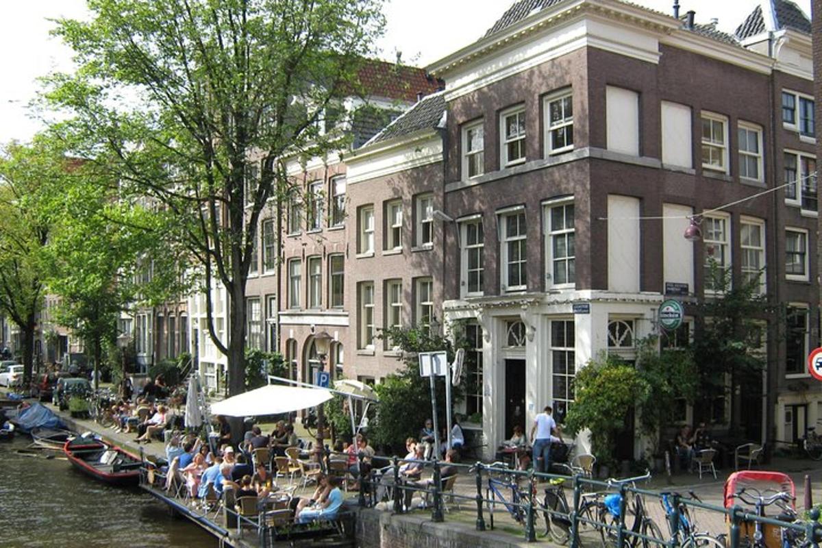 a group of people sitting at tables next to a river