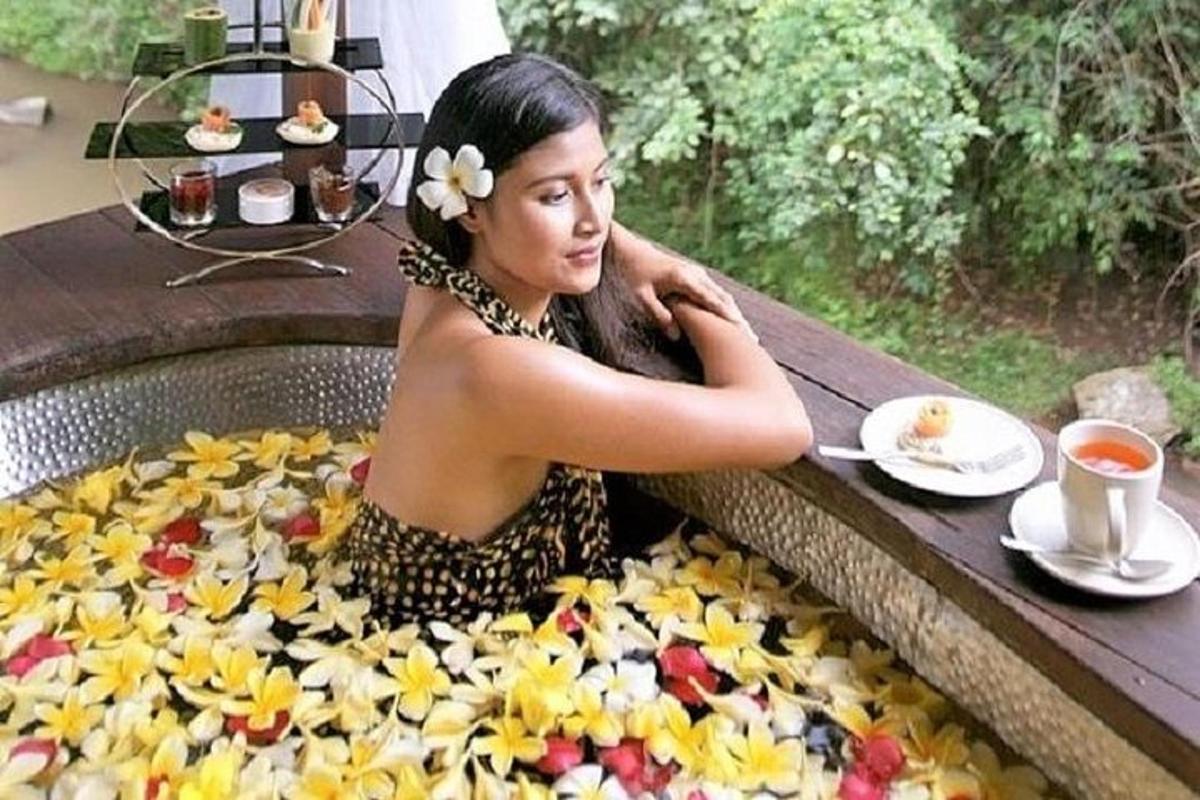 a woman sitting in a bath tub filled with flowers