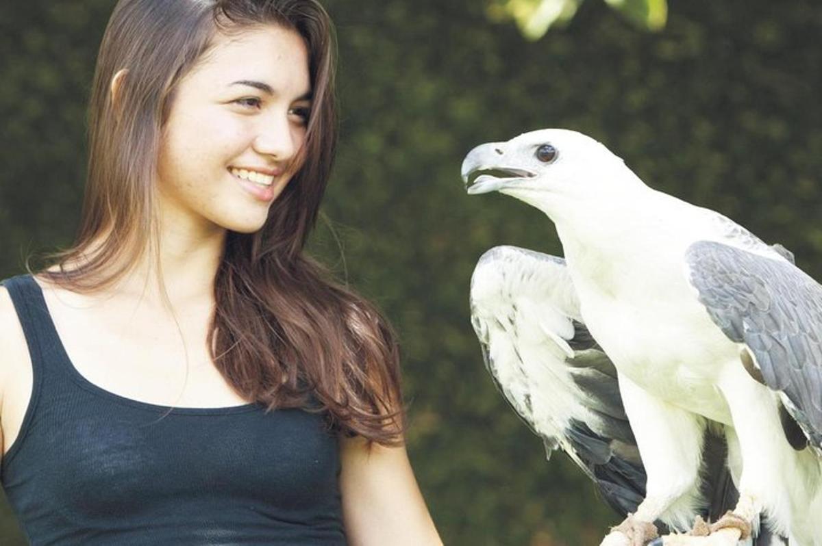 a woman holding a white bird in her hand