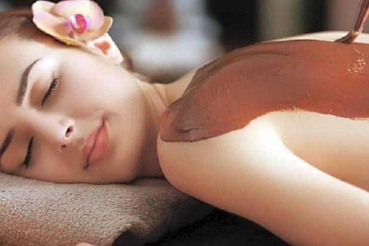 a young woman laying on a towel with a flower on her head