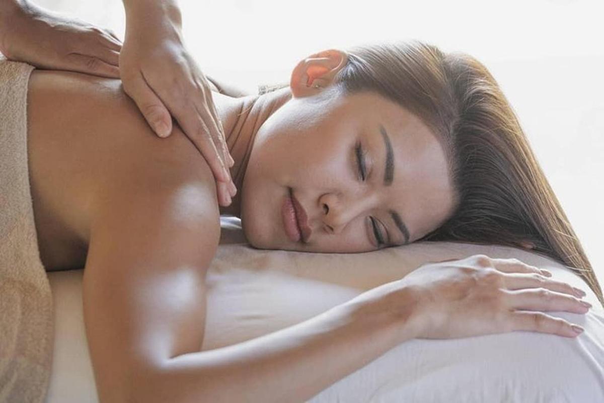 a woman laying on a bed with her head on a pillow