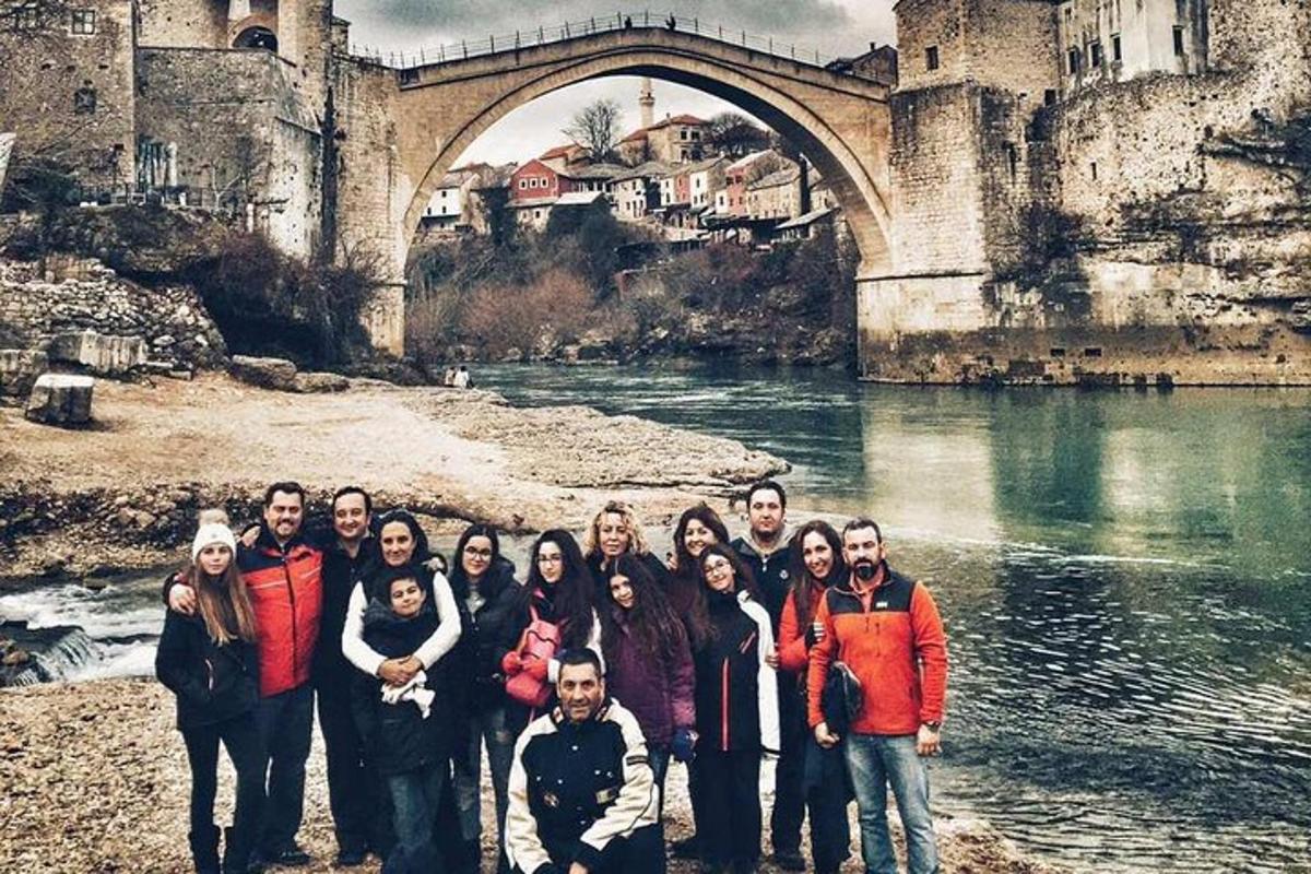 a group of people standing in front of a bridge