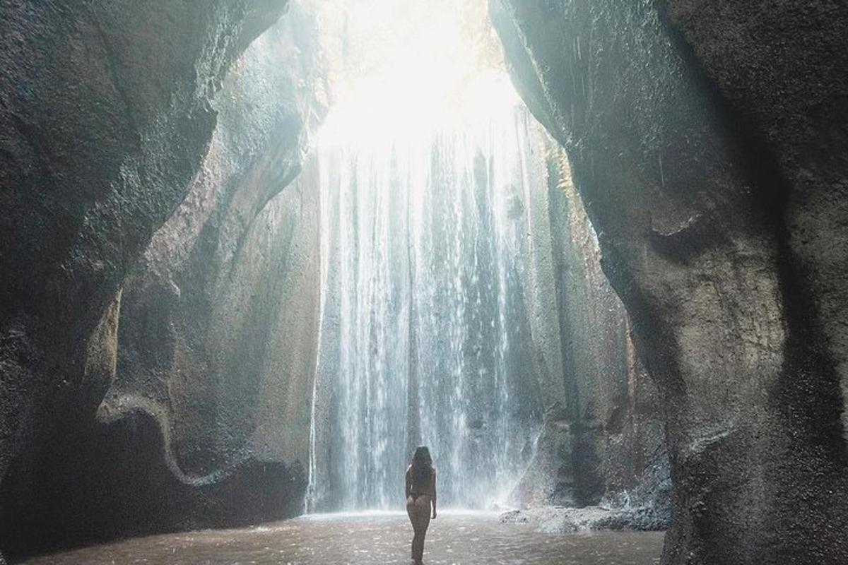 a woman standing in front of a waterfall